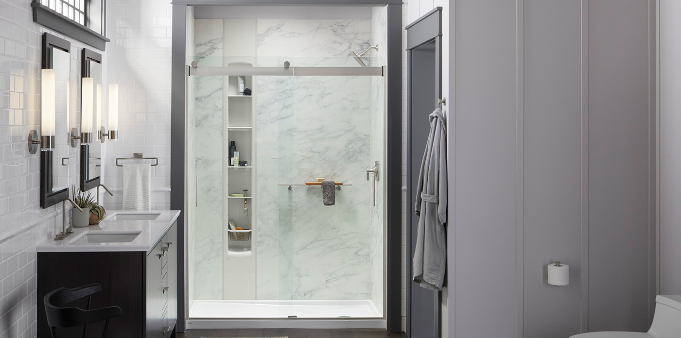 Marble-look walk-in shower with sliding glass door and built-in shelves